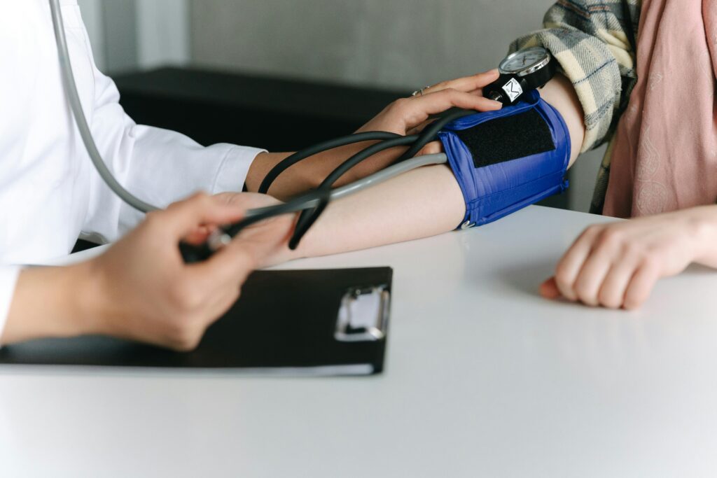 A healthcare worker uses a sphygmomanometer to check a patient